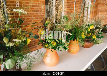 Élégantes pièces maîtresses de fleurs sauvages ornant une table de fête lors d'un événement intérieur Banque D'Images