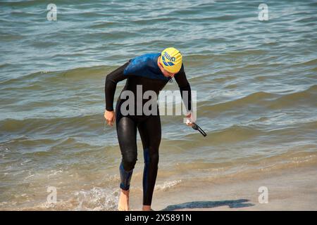 Sabaris, Baiona, Pontevedra, Espagne ; 15 juillet 2023 ; les compétiteurs de triathlon sortent de l'eau dans leurs combinaisons Banque D'Images