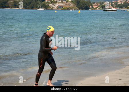 Sabaris, Baiona, Pontevedra, Espagne ; 15 juillet 2023 ; les compétiteurs de triathlon sortent de l'eau dans leurs combinaisons Banque D'Images