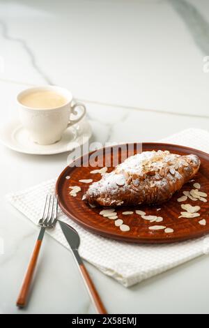 Croissant d'amandes sur plaque d'argile de près Banque D'Images