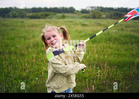 une petite fille s'est emmêlée dans la queue d'un cerf-volant Banque D'Images