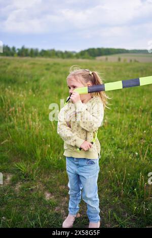 une petite fille s'est emmêlée dans la queue d'un cerf-volant Banque D'Images