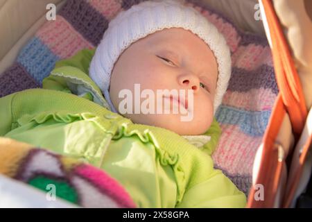 le soleil brille sur le visage d'un bébé dormant dans une poussette Banque D'Images