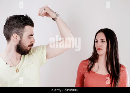 Couple dans un cadre décontracté où la jeune femme remarque une odeur désagréable venant de la direction de l'homme Banque D'Images