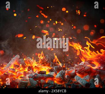 Charbon de bois pour barbecue fond - flammes chaudes et étincelles défocalisées abstraites Banque D'Images