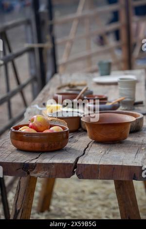 Pommes mûres dans un bol en céramique gros plan, poterie sur une table en bois, style de vie médiéval, nature morte. Photo de haute qualité Banque D'Images