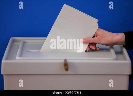 Leipzig, Allemagne. 08 mai 2024. Une femme jette un bulletin de vote pour les élections européennes dans une urne du nouvel hôtel de ville de Leipzig. Outre les élections européennes, des élections locales auront lieu en Saxe le 9 juin. Crédit : Jan Woitas/dpa/Alamy Live News Banque D'Images