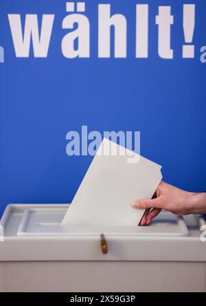 Leipzig, Allemagne. 08 mai 2024. Une femme jette un bulletin de vote pour les élections européennes dans une urne du nouvel hôtel de ville de Leipzig. Outre les élections européennes, des élections locales auront lieu en Saxe le 9 juin. Crédit : Jan Woitas/dpa/Alamy Live News Banque D'Images