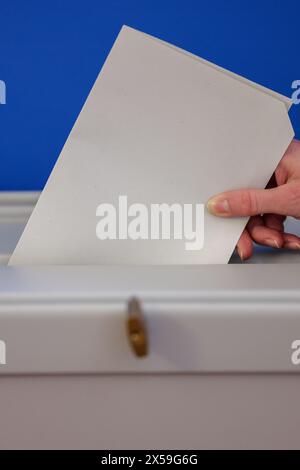 Leipzig, Allemagne. 08 mai 2024. Une femme jette un bulletin de vote pour les élections européennes dans une urne du nouvel hôtel de ville de Leipzig. Outre les élections européennes, des élections locales auront lieu en Saxe le 9 juin. Crédit : Jan Woitas/dpa/Alamy Live News Banque D'Images