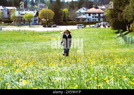 la fille courant sur le champ fleuri Banque D'Images