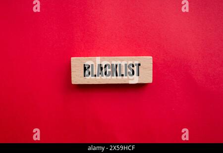 Mot de liste noire écrit sur bloc de bois avec fond rouge. Symbole de liste noire conceptuelle. Copier l'espace. Banque D'Images