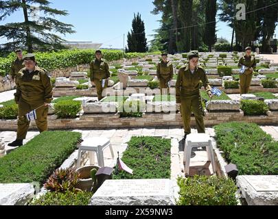 Jérusalem, Israël. 08 mai 2024. Les soldats israéliens placent des drapeaux nationaux avec des rubans noirs sur les tombes des soldats avant la Journée du souvenir des soldats tombés au mont. Cimetière militaire Herzl à Jérusalem, mercredi 8 mai 2024. Israël observera le jour du souvenir du coucher du soleil le 12 mai jusqu'au coucher du soleil le 13 mai, date à laquelle commence le jour de l'indépendance. Photo de Debbie Hill/ crédit : UPI/Alamy Live News Banque D'Images