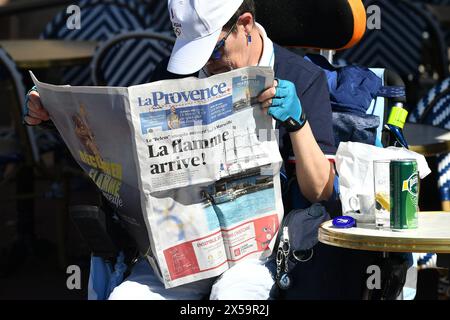 Marseille, France. 8 mai 2024. Un habitant lit un morceau de journal avant l'arrivée de la flamme olympique au vieux port de Marseille, dans le sud de la France, le 8 mai 2024. Crédit : Julien Mattia/ Xinhua/Alamy Live News Banque D'Images
