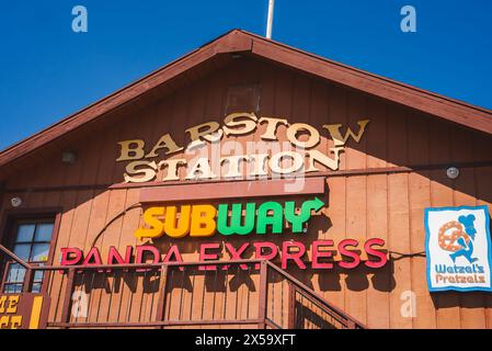 Bâtiment rustique avec panneau de GARE BARSTOW, logos de restauration rapide, Blue Sky Barstow, route 66 Banque D'Images