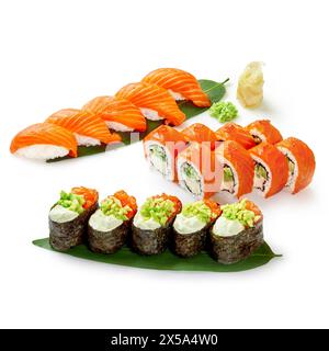 Ensemble de sushis au saumon séduisant composé de nigiri, gunkan et rouleaux avec garnitures délicates et garnitures de saumon frais, élégamment présentés sur une feuille de bambou Banque D'Images