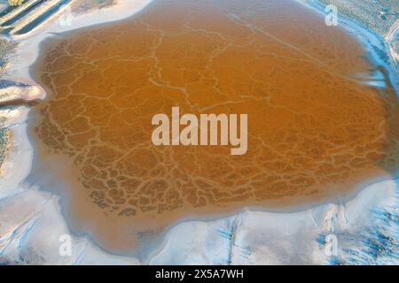 Prise de vue aérienne capturant les motifs complexes et les teintes chaudes d'un lagon salé situé près de Tolède, en Espagne Banque D'Images