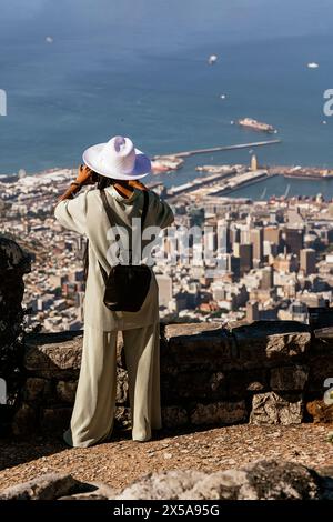 Vue arrière des regards touristiques féminins à la mode à la vue panoramique de Cape Town, Afrique du Sud depuis un point de vue élevé sur table Mountain. Banque D'Images