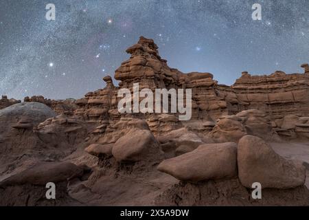 « Vue spectaculaire de la voie lactée qui brille sur les hoodoos dans le parc d'État de Goblin Valley, Utah, sous le ciel céleste nocturne. » Banque D'Images