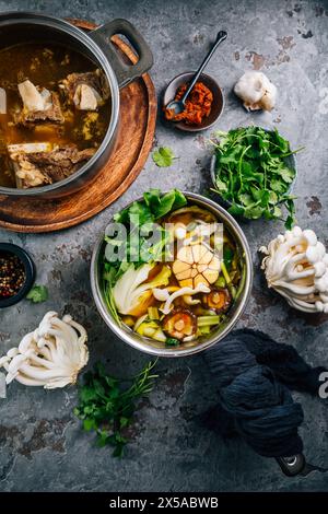 Bouillon de légumes maison avec bouillon d'os de bœuf dans des pots avec des ingrédients Banque D'Images