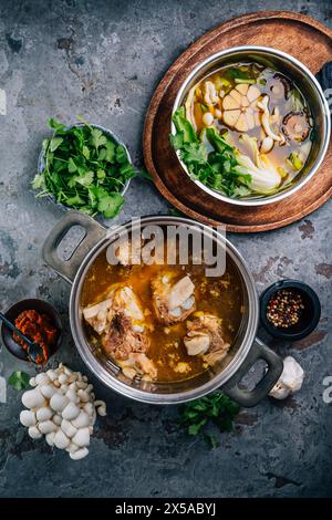 Bouillon de légumes maison avec bouillon d'os de bœuf dans des pots avec des ingrédients Banque D'Images