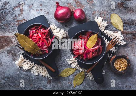 Oignons rouges marinés dans un bol sur un fond gris. Apéritif, condiment ou garniture, aliments fermentés sains. Banque D'Images