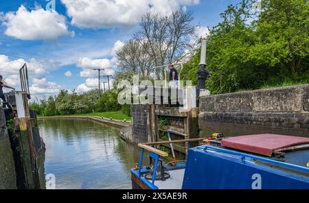 Grand Union canal main Line, Calcutt Locks, Angleterre – Un bateau étroit dans l'écluse supérieure avec les portes d'écluse fermant par une journée d'été ensoleillée brillante contre un ciel bleu Banque D'Images