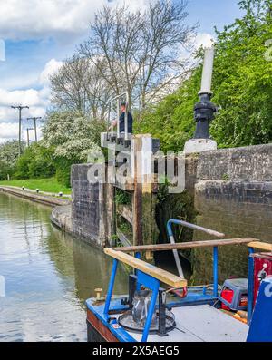 Grand Union canal main Line, Calcutt Locks, Angleterre – Un bateau étroit dans l'écluse supérieure avec les portes d'écluse fermant par une journée d'été ensoleillée brillante contre un ciel bleu Banque D'Images