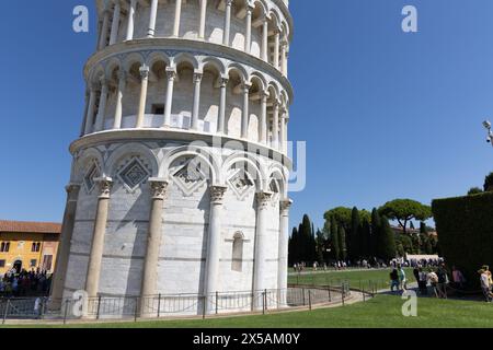 Pise, Italie - 10 septembre 2023 : Fondation et partie inférieure de la tour penchée de Pise, Italie. Jour d'été, ciel bleu clair et ensoleillé. Touristes visibles sur g Banque D'Images