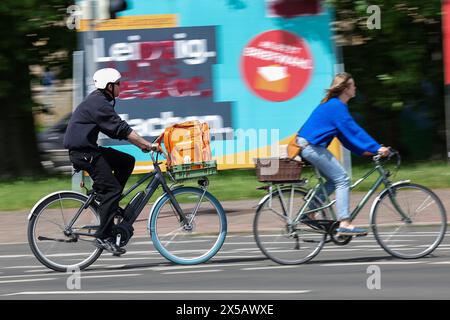 Leipzig, Allemagne. 08 mai 2024. Un homme traverse la ville avec un sac du service de livraison Lieferando dans son panier à vélo. Crédit : Jan Woitas/dpa/Alamy Live News Banque D'Images