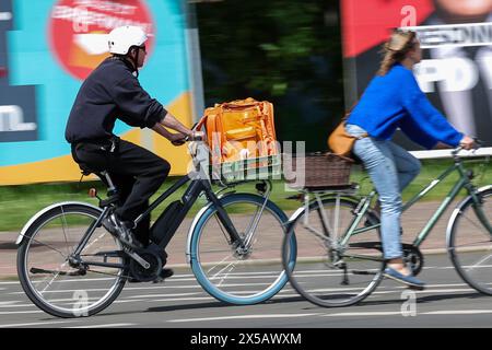 Leipzig, Allemagne. 08 mai 2024. Un homme traverse la ville avec un sac du service de livraison Lieferando dans son panier à vélo. Crédit : Jan Woitas/dpa/Alamy Live News Banque D'Images