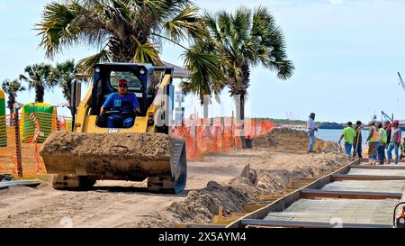 PORT ARANSAS, TX - 29 février 2020 : un ouvrier conduit une chargeuse frontale CAT 289D jaune pour déplacer une charge de terre sur un chantier près de l'eau. Banque D'Images