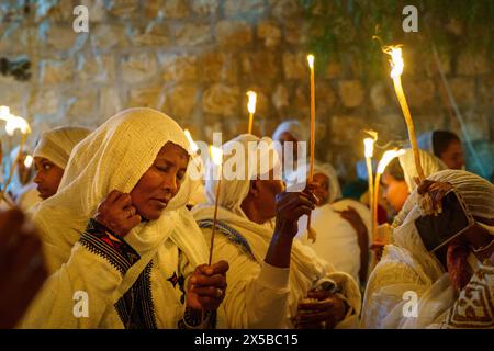 4 mai 2024, Jérusalem, Israël : une femme éthiopienne tient une bougie en priant pendant la cérémonie du feu sacré de l’Église orthodoxe éthiopienne à Jérusalem. La cérémonie du Saint feu est célébrée par les églises orthodoxes de l'église du Saint-Sépulcre à Jérusalem chaque année avant Pâques. Cet événement spirituel et religieux est l’un des rituels les plus importants du christianisme orthodoxe, et de nombreux pèlerins du monde entier se rassemblent pour en témoigner. Au cours de la cérémonie, le patriarche grec entre dans les aedicules où se trouve le tombeau de Jésus, priant jusqu'à ce que le feu Saint soit censé être allumé par Banque D'Images