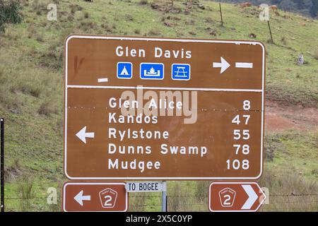 Vallée de Capertee dans la région de Nouvelle-Galles du Sud et panneau routier avec les directions et les distances sur la route touristique, NSW, Australie Banque D'Images