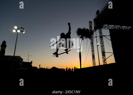 Salvador, Bahia, Brésil - 17 mars 2019 : un jeune skateur est vu sauter contre le coucher du soleil sur la place Farol da Barra dans la ville de Salvador Banque D'Images