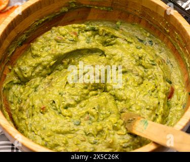 Guacamole fraîche maison dans un bol en bois. Concept de restauration de fête. Banque D'Images