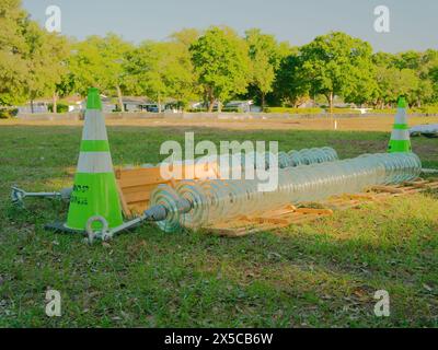 Isolateurs de ligne électrique haute tension sur l'herbe verte. Pour les lignes haute tension. Cône de sécurité vert avec des tendeurs avec des arbres verts Banque D'Images