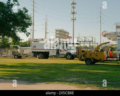 Large vue sur l'herbe verte et la saleté jusqu'au camion utilitaire blanc avec une sous-station électrique à l'arrière. En fin d'après-midi. Ciel bleu en arrière-plan. Personne Banque D'Images