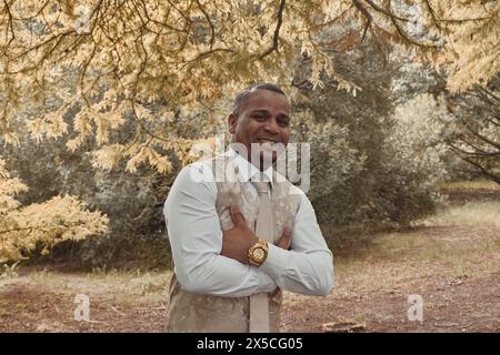 Homme latino-américain souriant à la caméra, il est les bras croisés. Concept de saison d'automne, l'homme est confiant, confiant. Banque D'Images