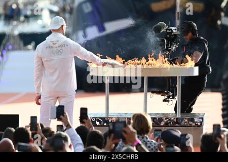 Marseille, France. 8 mai 2024. Le chanteur français Jul allume le chaudron olympique lors d’une cérémonie accueillant la flamme olympique de Paris 2024 au Vieux-Port de Marseille, dans le sud de la France, le 8 mai 2024. Crédit : Julien Mattia/Xinhua/Alamy Live News Banque D'Images