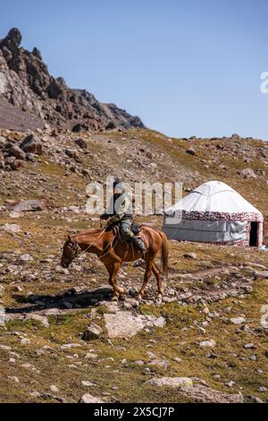 Cavalier et yourte dans la haute vallée, vallée de Keldike sur le chemin du col d'Ala Kul, montagnes de Tien Shan, Kirghizistan Banque D'Images