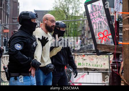 Un homme est emmené par des policiers en civil en état d'arrestation après que la police a franchi des barricades pour mettre fin à une occupation étudiante pro-palestinienne à l'Université d'Amsterdam. La police démantèle une manifestation étudiante pro-palestinienne et une occupation à l'Université d'Amsterdam, en utilisant des matraques, des boucliers et du matériel de terrassement. L'affrontement s'est ensuivi alors que les manifestants se sont mobilisés pour la solidarité palestinienne dans un climat de tensions, les forces de l'ordre sont intervenues pour disperser la foule, ce qui a entraîné des affrontements et des arrestations. (Photo Michael Currie/SOPA images/SIPA USA) Banque D'Images