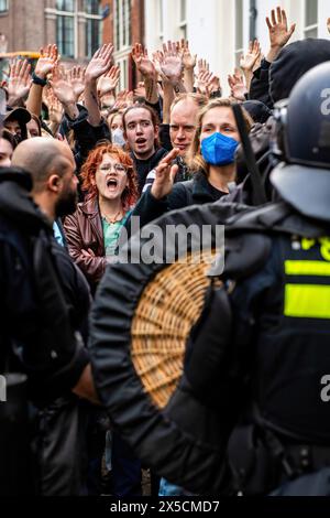 Amsterdam, pays-Bas. 08 mai 2024. Un groupe de partisans lève la main et demande à la police de les laisser partir après que la police ait franchi des barricades pour mettre fin à une occupation étudiante pro-palestinienne à l’Université d’Amsterdam. La police démantèle une manifestation étudiante pro-palestinienne et une occupation à l'Université d'Amsterdam, en utilisant des matraques, des boucliers et du matériel de terrassement. L'affrontement s'est ensuivi alors que les manifestants se sont mobilisés pour la solidarité palestinienne dans un climat de tensions, les forces de l'ordre sont intervenues pour disperser la foule, ce qui a entraîné des affrontements et des arrestations. Crédit : SOPA images Limited/Alamy Live News Banque D'Images