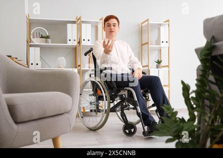 Jeune homme d'affaires en fauteuil roulant au bureau Banque D'Images
