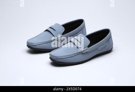 mocassins en cuir bleu clair glisser sur des chaussures isolées sur fond gris Banque D'Images