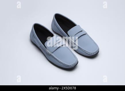 mocassins en cuir bleu clair glisser sur des chaussures isolées sur fond gris Banque D'Images