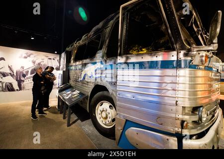 Les visiteurs du musée examinent le bus brûlé qui transportait Freedom Riders, National civil Rights Museum, Memphis, Tennessee, États-Unis. Banque D'Images