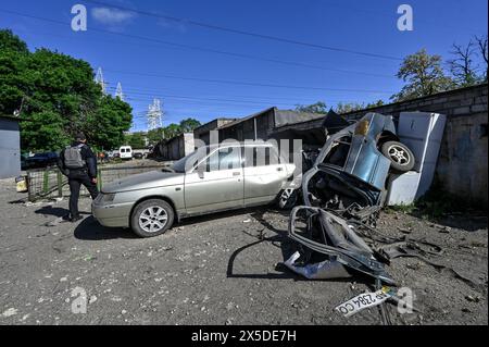 Non exclusif : ZAPORIZHZHIA, UKRAINE - 8 MAI 2024 - Un policier se tient près de voitures endommagées dans une coopérative de garage après la nuit massive Russi Banque D'Images