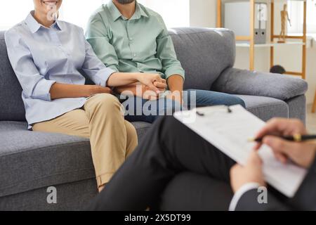 Couple familial souriant se tenant par la main lors d'une consultation psychologue Banque D'Images