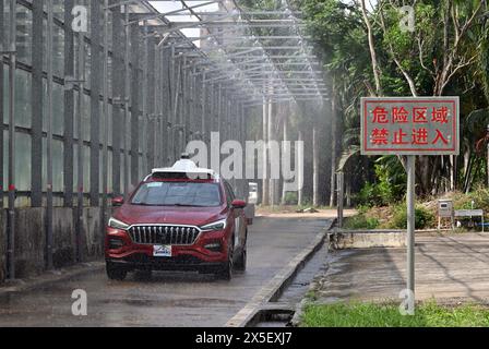 (240509) -- HAIKOU, 9 mai 2024 (Xinhua) -- Une voiture est en cours d'essai pour conduite autonome par temps pluvieux à Qionghai, dans la province de Hainan, dans le sud de la Chine, le 8 mai 2024. Le premier site d'essai automobile en Chine est à Qionghai City. Chaque année, des centaines de voitures sont transportées ici pour être testées avant d’arriver sur le marché. Le site d'essai couvre une superficie de 1 200 mu (80 hectares), avec des routes à grande vitesse, des champs d'exposition et d'autres installations, qui peuvent effectuer divers tests et évaluations tels que la fiabilité du véhicule, la durabilité et la conduite assistée intelligente. (Xinhua/Guo Cheng) Banque D'Images