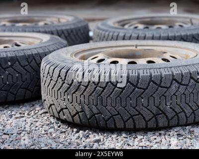 Quatre roues de voiture couchées sur le gravier. Gros plan. Banque D'Images